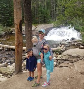 Mom with three kids standing by Copeland Falls Waterfall in Rocky Mountain National Park.